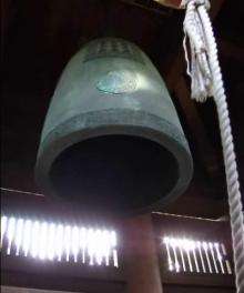 A large bell, seen from below, is rung by being struck by a hanging beam