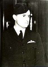 Informal half portrait of man in dark military uniform with forage cap