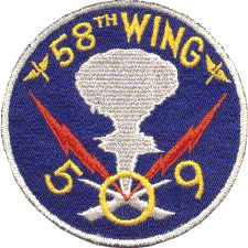 A blue circle with yellow writing. At the top it says "58th Wing"; at the bottom is the number 509. In the centre there is a white mushroom cloud with two red lightning bolts.