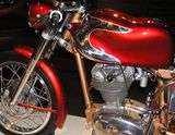 The front half of pristine 1960s Italian single-cylinder motorcycle with polished chrome accents on the so-called "jellymould" style gas tank.