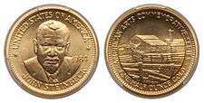 A gold medallion depicting a man and a rural farm scene