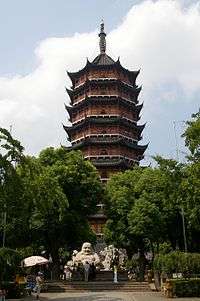A nine-story-tall octagonal pagoda made out of orange brick. Each floor is separated by an eave. The eaves of the pagoda each have eight upward curving corners.