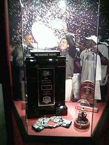 Coaches' Trophy and championship rings in a displaycase.