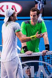 João Sousa argues with the umpire, while Andy Murray waits to shake hands with him.