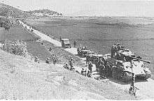 A column to soldiers and vehicles move down a river