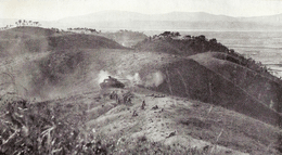 Infantry deployed on the crest of a hill, while in the background a tank provides support.
