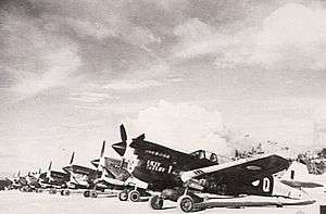 Row of single-engined fighter aircraft parked on airfield