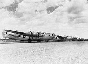 A row of four-engined military aircraft parked on an airfield