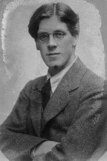 A black and white photograph of a young man wearing glasses