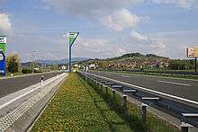 A view of the motorway next to a rest area, with a rest area sign in the background