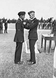 Full-length picture of two men in dark military uniforms facing each other