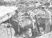 Soldiers in a gun pit with a mortar tube