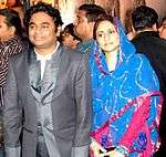 Man in grey jacket and woman in sari