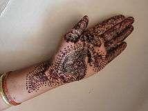 An open hand covered in artistic designs.