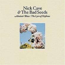 A photograph of a series of flowers in part of an arc are surrounded by a cream coloured border. Black text above the photograph reads "Nick Cave & The Bad Seeds" and italicised black text reads "Abattoir Blues / The Lyre of Orpheus".