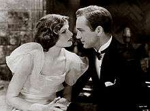Hepburn and David Manners acting in A Bill of Divorcement. They are holding hands and looking at each other emotionally.
