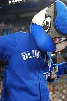 A mascot with a blue jay reminiscent head, and a human body.