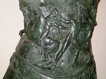 a piture beaten out on the bronze of the breastplate. A man with a shield drags a naked youth by the hair from his horse.