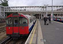 A westbound Piccadilly Line train, formed of 1973 stock, stands at Acton Town tube station with a service for Northfields.