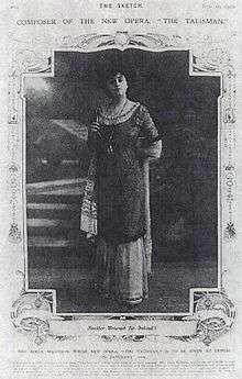 A magazine page containing a framed picture of a woman in a long dress standing and gazing straight at the camera