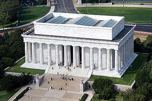 An aerial photo a large white building with big pillars.