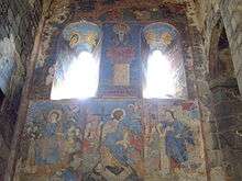 Colourful paintings of saints on the stone walls and inside the arches.
