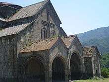 Gabled roof with extensions over a covered entrance with two gabled arches.