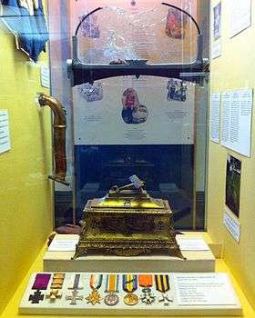 Medals and other memorabilia in glass case.