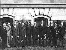 Ten men in 1920s formal dress standing in a row