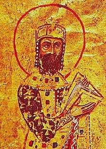 Miniature of a crowned bearded man in gold and purple robes, holding a book, on golden background