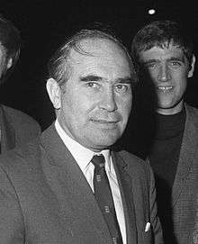 Alf Ramsey wearing a dark suit, a white shirt and a dark tie
