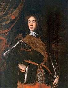 Formal portrait of Mary's father as a young man. He has long bushy hair, a fleshy face and wears a black suit of armour, with a brown shoulder sash.