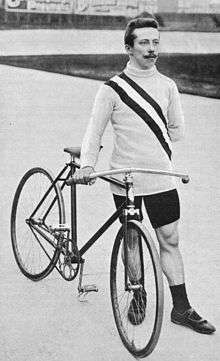 A picture of Alfred Görnemann beside a bike.