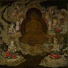 A deity in frontal view surrounded by attendants floating on clouds.