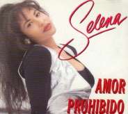 A Hispanic woman, who is wearing a black spandex that is underneath a golden-plain shirt, is tilting her head towards the viewer of the picture and posing; titled with the singer's name and song.
