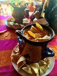 An anafre in La Esperanza-Intibucá, Honduras, consisting of melted quesillo cheese, mushrooms and sausage in an earthenware pot, along with tortilla chips for dipping