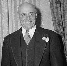 A smiling, bald man in a suit