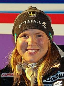 Anja Parson, close in on her face, as she smiles.  She is wearing a black ski hat.