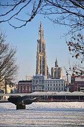 Snow-covered Antwerp, with government buildings in the background against a blue sky