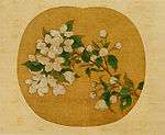 Blossoms and leaves on a branch painted on an oval background.