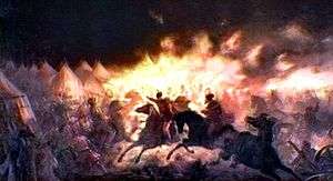 Horsemen holding torches in a camp of tents