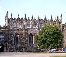 A two to three storey high stone building.  The building is topped with castellations and pinnacles