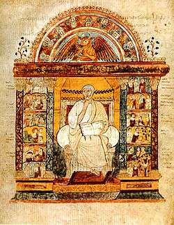 An illuminated manuscript illustration of a central seated figure holding an open book. He is flanked by two colonnades, which are filled with small scenes. Over the central figure is an arch with surmounts a winged bull.