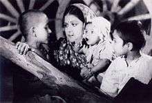  A screenshot from the film Aurat showing an Indian woman with three children.