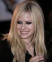 A picture of a blonde woman looking to her right wearing a black shirt and smiling