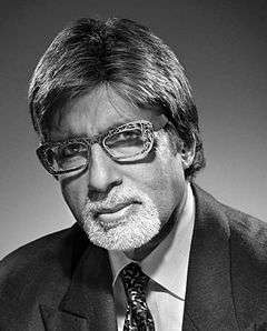 Amitabh Bachchan is looking at the camera.