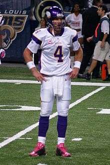 A white man wearing a white and purple American football uniform. His helmet and the trim on the sleeves of his jersey are purple and there is a large numeral "4" in purple on his chest.