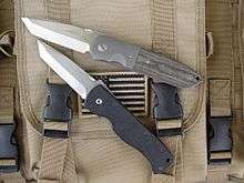 Two similar tanto bladed fighting knives one a custom the other a factory piece.