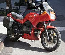 Red BMW K75S with topbox and panniers, parked on a city street