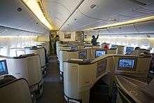 Airliner cabin. Rows of seats arranged between two aisles.